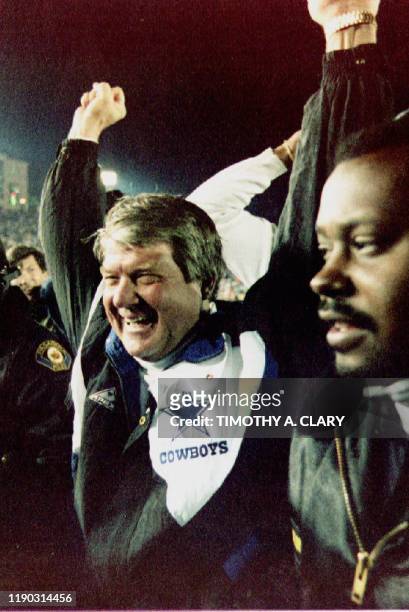 Dallas Cowboys coach Jimmy Johnson raises his hands in the air as he leaves the field after his team defeated the Buffalo Bills 52-17 to win Super...