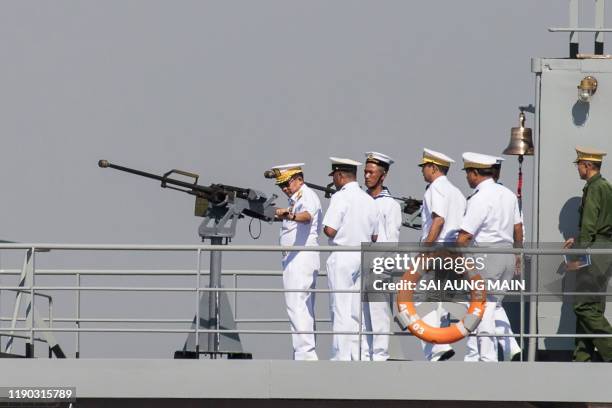 Myanmar's commander-in-chief Senior General Min Aung Hlaing inspects a weapon during a celebration to mark the Myanmar navy's 72nd anniversary in...