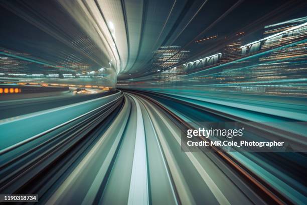 long exposure light trails of  train moving in tunnel,automated transit system controlled entirely by computers with no drivers on board,transportation technology,futuristic abstract background - smart city concept stock-fotos und bilder