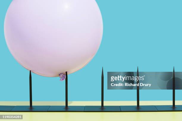 balloon impaled on metal spikes - blowing up balloon stock pictures, royalty-free photos & images