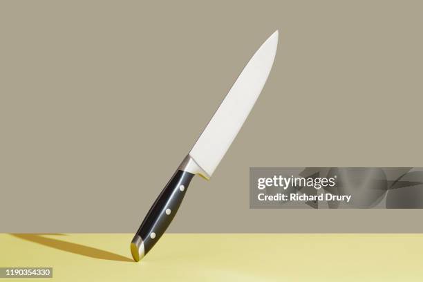 kitchen knife balanced on its end - keukenmes stockfoto's en -beelden