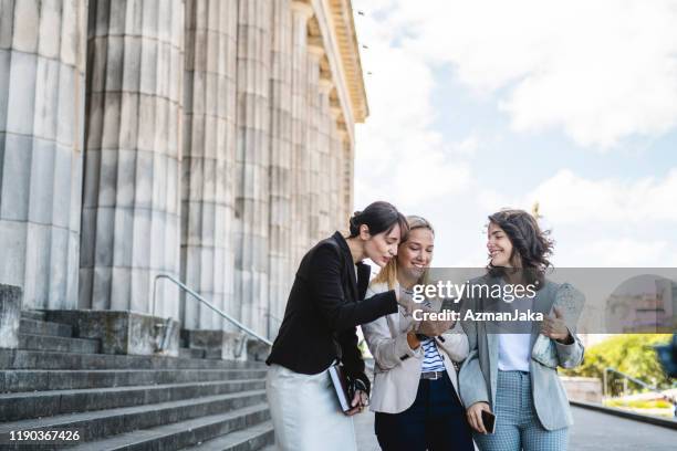 female law school friends checking smart phone - law student stock pictures, royalty-free photos & images