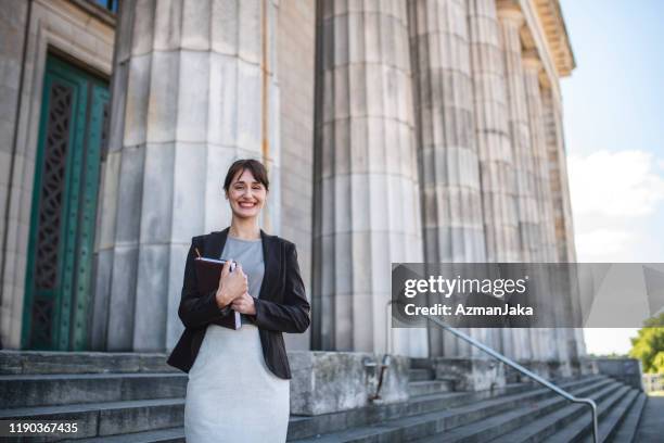 mid volwassen vrouwelijk recht student verlaten universiteitsgebouw - onderwijsinstituten en organisaties stockfoto's en -beelden