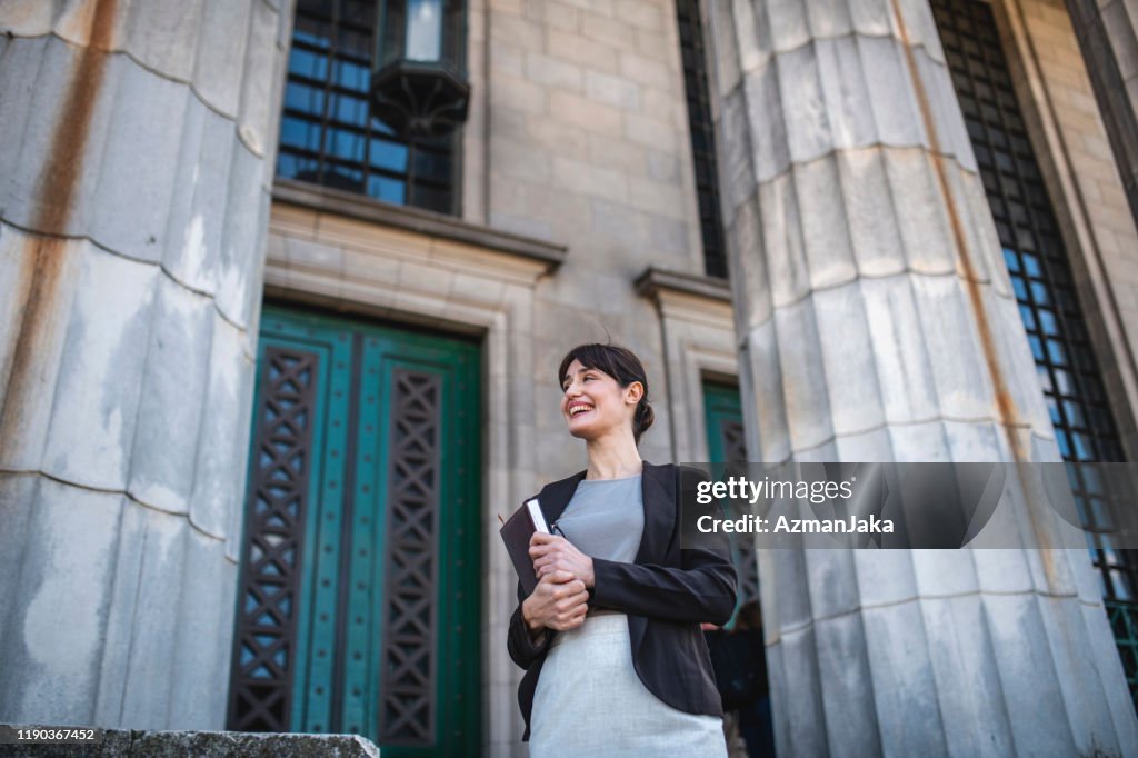 Smiling Female Hispanic Law Student at Entrance to School