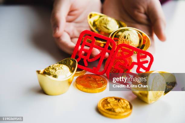 chinese new year celebration-woman holding chinese gold ingot - lunar calendar stock-fotos und bilder