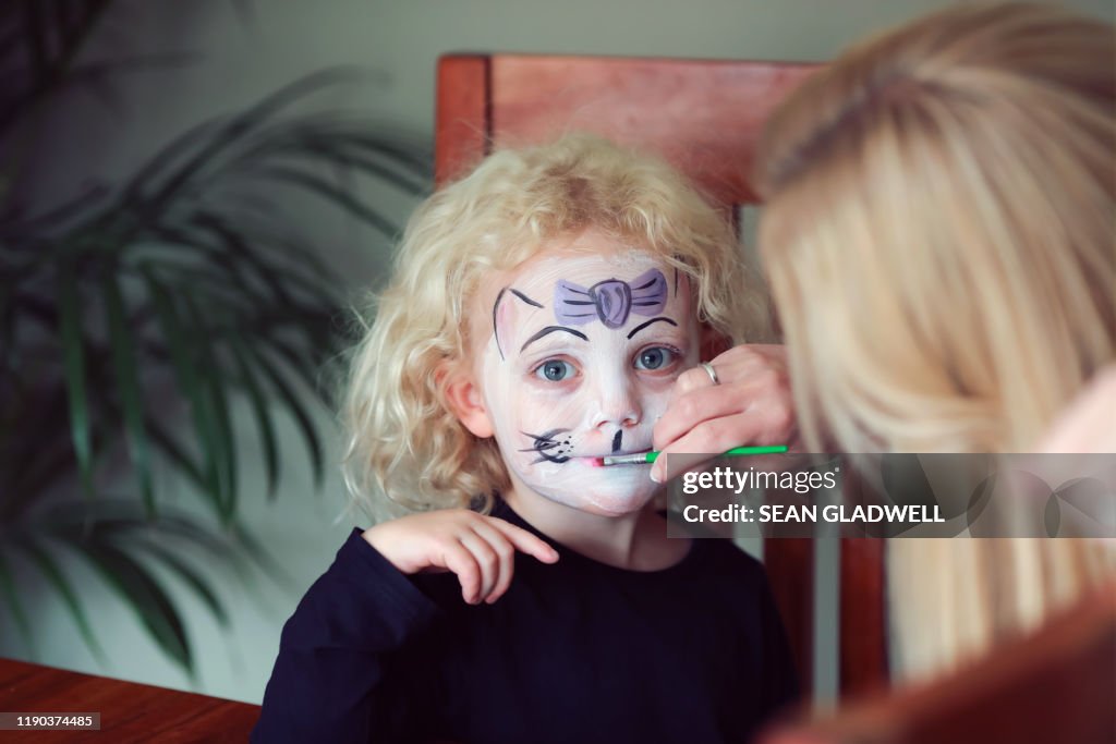 Face painting young girl with blond hair