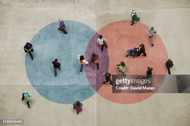 pedestrians on a concrete floor with a blue and red venn diagram. - diagramme de venn photos et images de collection