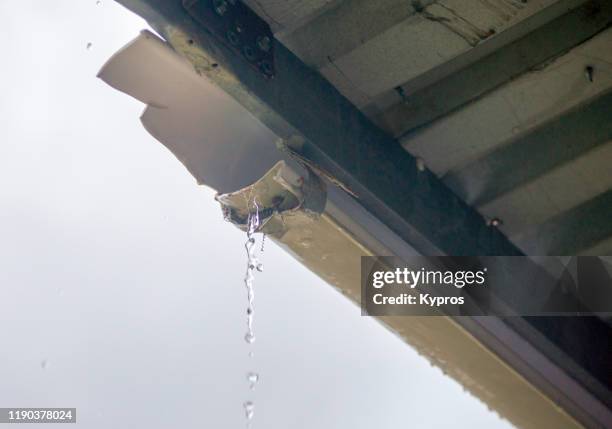 broken plastic gutter during rainstorm - damaged gutter stock pictures, royalty-free photos & images