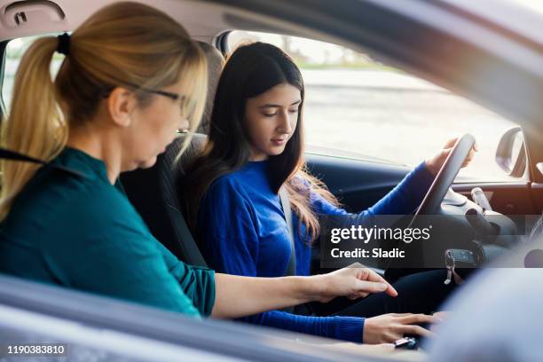 adolescente teniendo clase de manejo con instructora femenina - examen de conducir fotografías e imágenes de stock