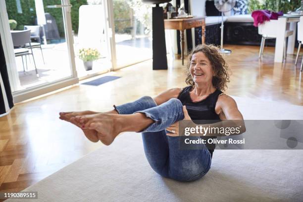 happy mature woman exercising at home - pilates stockfoto's en -beelden