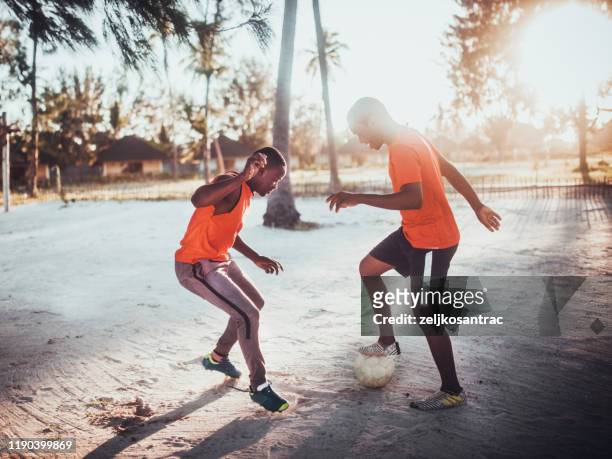 african teenager  playing soccer - hunky guy on beach stock pictures, royalty-free photos & images