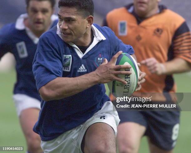 Samoan flanker Semo Sititi runs with the ball on his way to scoring a try during the Rugby World Cup quarter-final play-off match between Scotland...