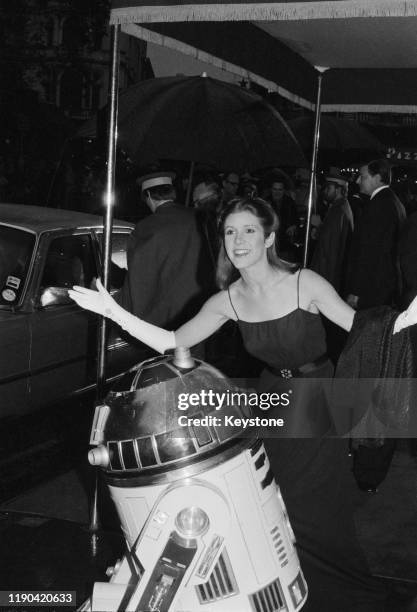 American actress, writer, and comedian Carrie Fisher and fictional character R2-D2 arrive at the royal premiere of 'The Empire Strikes Back' at the...