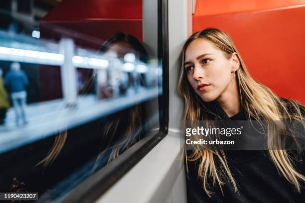 mooie vrouw in metro trein - woman looking out window stockfoto's en -beelden