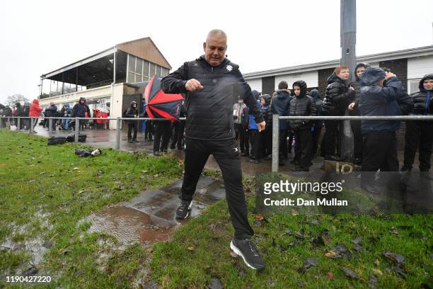 Warren Gatland, Coach of the Barbarians avoids a muddy puddle as he makes his way onto the pitch during Barbarians training on November 27, 2019 in...