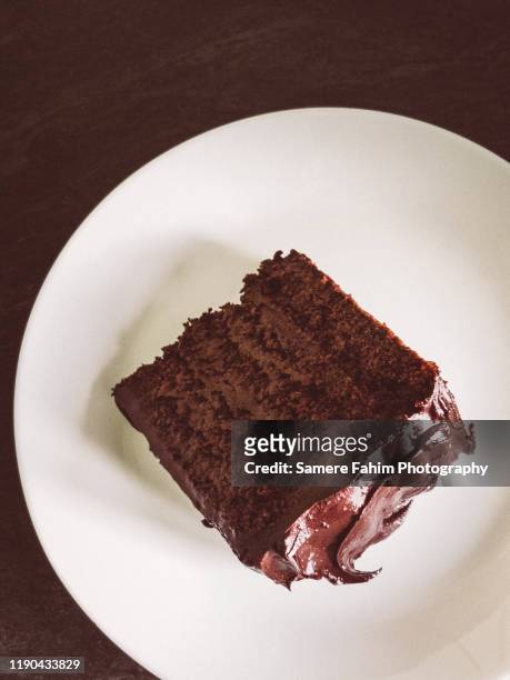 a slice of chocolate layer cake served on a plate - gateaux stockfoto's en -beelden