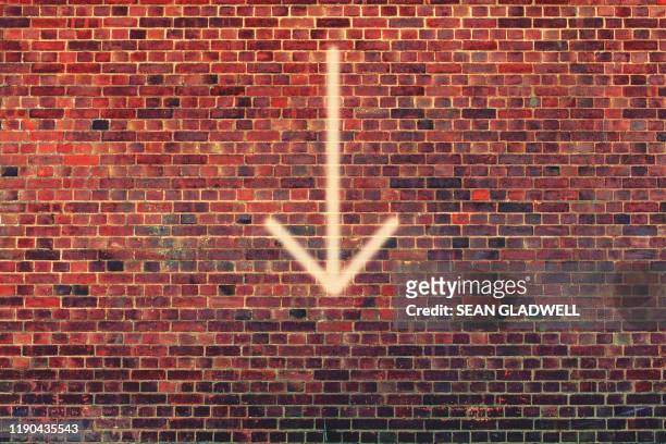 arrow pointing down on wall - arrow sign stock pictures, royalty-free photos & images
