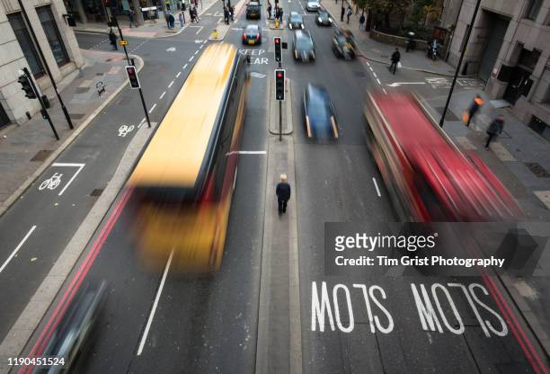 high angle view of blurred vehicles and man walking between traffic on a busy city street. london. uk. - tracciatura stradale foto e immagini stock