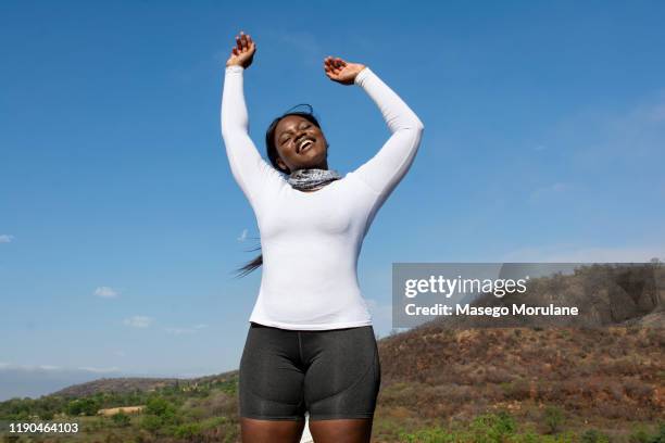 happy female hiker reaching the top - showus skin stock pictures, royalty-free photos & images