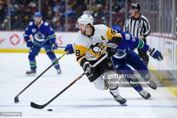 Pittsburgh Penguins Defenceman Kris Letang is pursued by Vancouver Canucks Center Tim Schaller during their NHL game at Rogers Arena on December 21,...