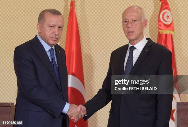 Tunisian President Kais Saied shakes hands with his Turkish counterpart Recep Tayyip Erdogan following their joint press conference at the...