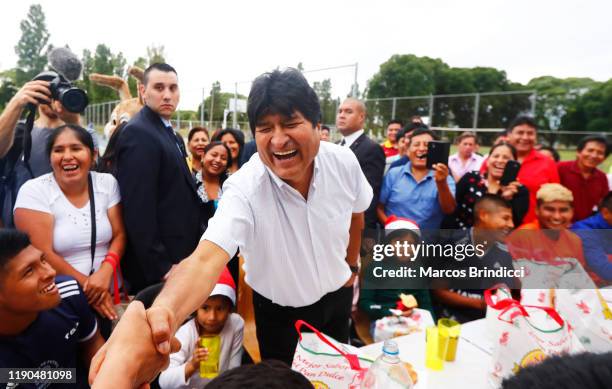 Exiled former President of Bolivia Evo Morales laughs as he shakes hands during a Christmas breakfast with members of the Bolivian community of...