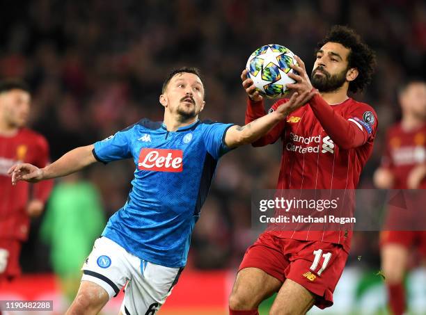Mohamed Salah of Liverpool holds onto the ball as Mario Rui of Napoli reaches for it during the UEFA Champions League group E match between Liverpool...
