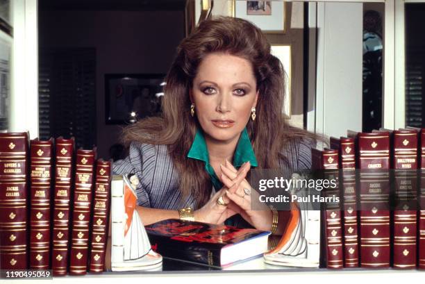 Jackie Collins posses with all the books she had written in her Beverly Hills that she Designed Herself March 21, 1998 Beverly Hills, California