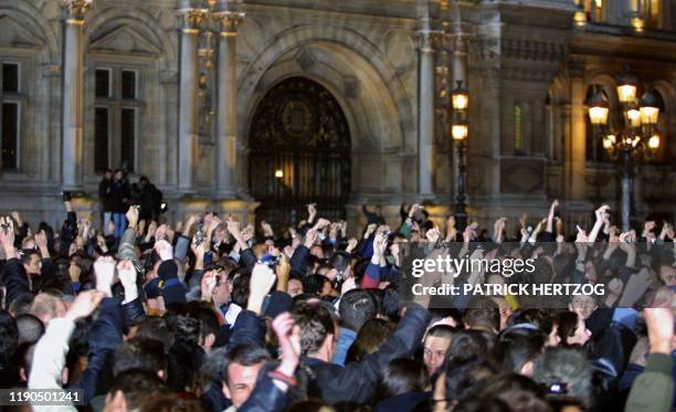 La foule massée devant l'hôtel de ville agite des trousseau de clés, le 18 mars 2001 à Paris, après la victoire du socialiste Bertand Delanoë au...