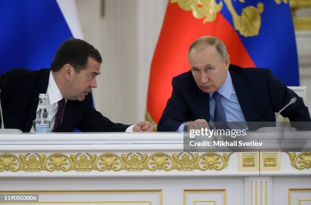 Russian President Vladimir Putin listens to Prime Minister Dmitry Medvedev during the State Council's meeting at Grand Kremlin Palace on December 26,...