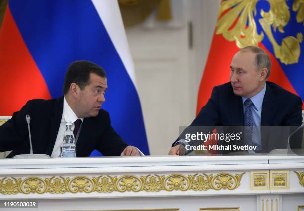 Russian President Vladimir Putin listens to Prime Minister Dmitry Medvedev during the State Council's meeting at Grand Kremlin Palace on December 26,...