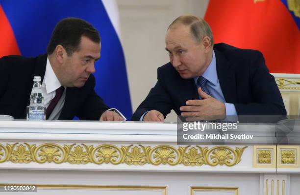 Russian President Vladimir Putin talks to Prime Minister Dmitry Medvedev during the State Council's meeting at Grand Kremlin Palace on December 26,...