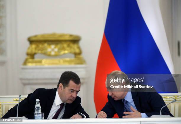 Russian President Vladimir Putin talks to Prime Minister Dmitry Medvedev during the State Council's meeting at Grand Kremlin Palace on December 26,...
