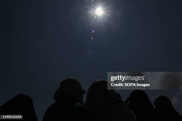 People wear eye protection goggles to watch the "ring of fire" solar eclipse in Lhokseumawe. The "ring of fire" solar eclipse occurred when the...