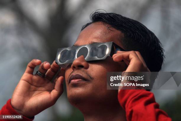 Man wears eye protection goggles to watch the "ring of fire" solar eclipse in Lhokseumawe. The "ring of fire" solar eclipse occurred when the shadow...