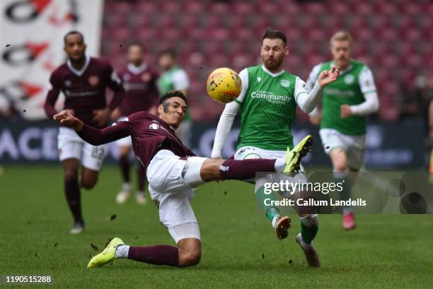 Sean Clare of Heart of Midlothian FC lunges in on Martin Boyle of Hibernian FC during the Ladbrokes Premiership match between Hearts and Hibernian at...