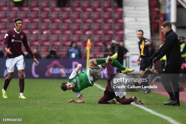 Loïc Damour of Heart of Midlothian FC takes out Lewis Stevenson of Hibernian FC during the Ladbrokes Premiership match between Hearts and Hibernian...