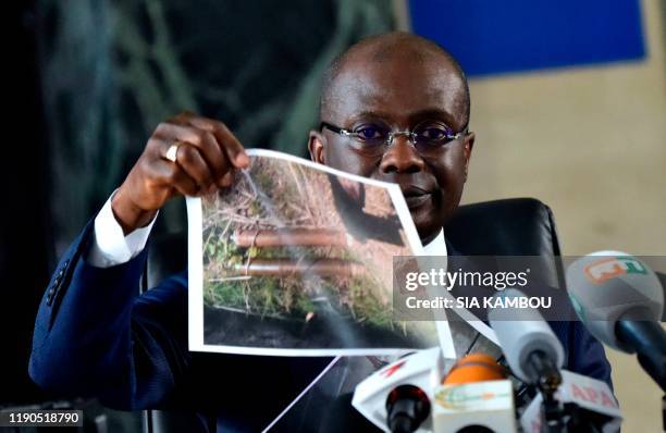 Ivorian State prosecutor Richard Adou shows pictures of seized weapons during a press conference at Abidjan's courthouse, in Abidjan, on December 26,...