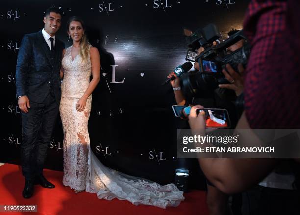 Uruguayan Barcelona forward Luis Suarez and his wife Sofia Balbi pose for photographers during a party for the renewal of their marriage vows in La...