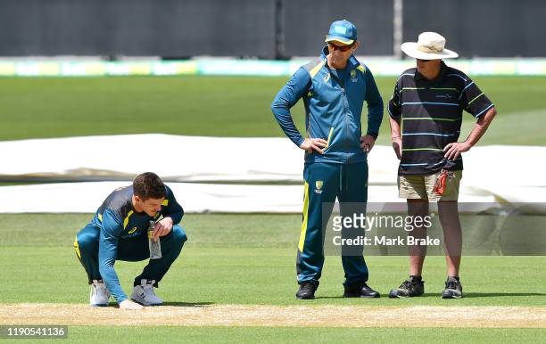 Tim Paine captain of Australia and Alex Justin Langer coach of Australia have a close look at the pitch during an Australian nets session at Adelaide...