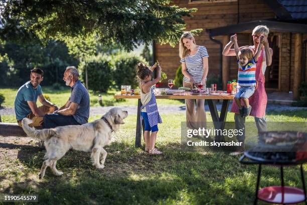 happy multi-generation family enjoying in garden party in the backyard. - multi generational family with pet stock pictures, royalty-free photos & images