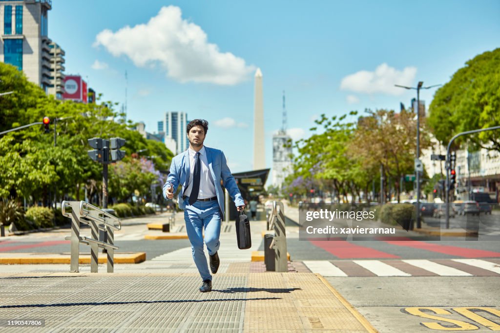 Young Businessman with Briefcase Running to Appointment