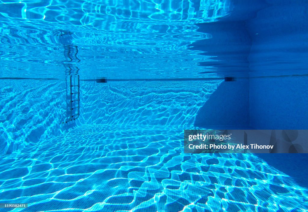 Empty swimming pool bottom view, blue clear water