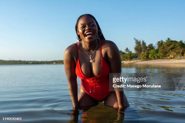 beautiful confident black woman in the ocean - beach hair stock-fotos und bilder