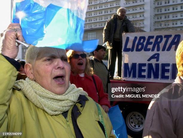 Supporter of Former President Carlos Menem raises an Argentine flag upon his arrival at the Supreme Court in Buenos Aires, Argentina, 26 June 2001....