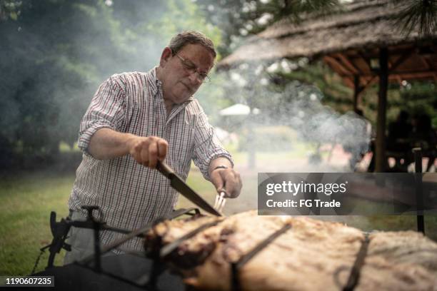hombre preparando una barbacoa - argentina steak fotografías e imágenes de stock