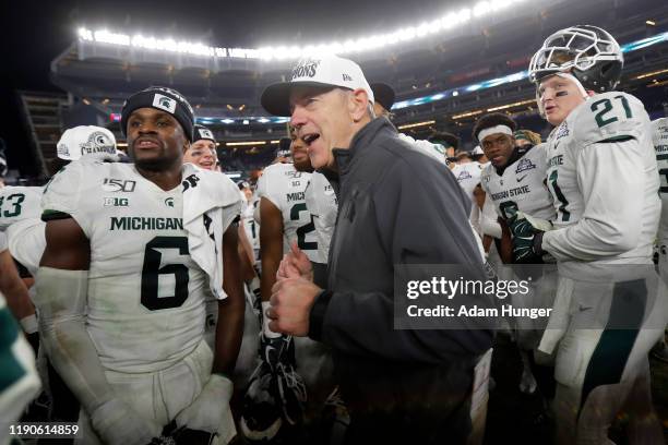Head coach Mark Dantonio of the Michigan State Spartans celebrates with his players after defeating the Wake Forest Demon Deacons in the New Era...