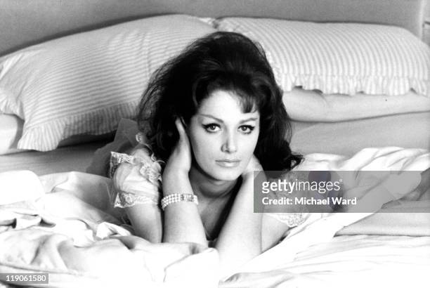 British writer Jackie Collins poses in bed, 1963.