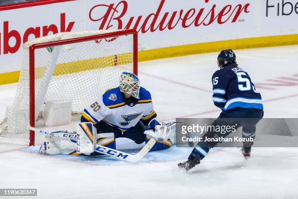 Goaltender Jordan Binnington of the St. Louis Blues makes a pad save on Mark Scheifele of the Winnipeg Jets during third period action at the Bell...