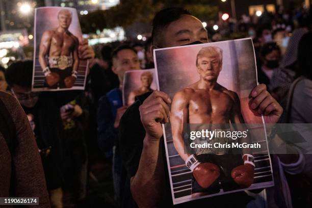 Pro-democracy protesters hold posters of US President Donald Trump during a Thanksgiving Day rally at Edinburgh Place on November 28, 2019 in Hong...